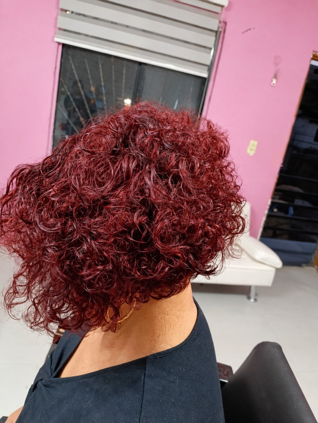 Cabello corto rizado en tono vino intenso
